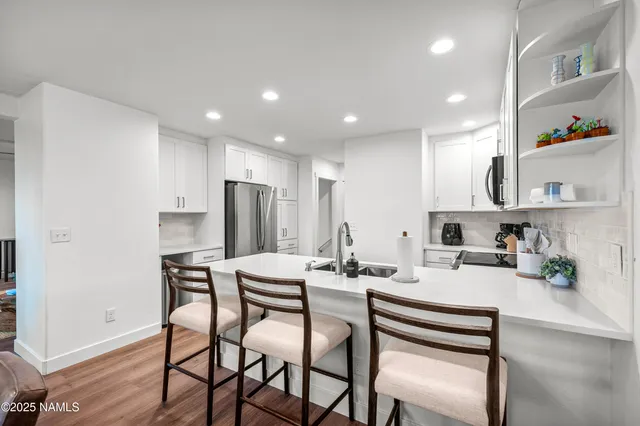 a kitchen with a dining table chairs refrigerator and cabinets