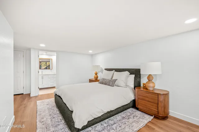 a bedroom with a bed and wooden floor
