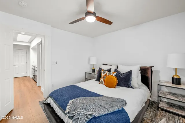 a bedroom with a bed and a chandelier fan