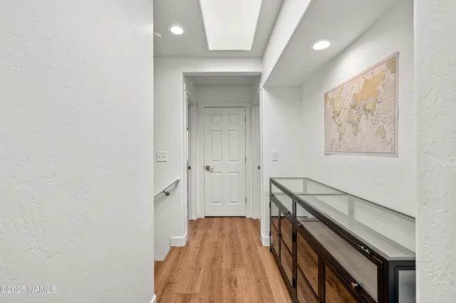 a view of a hallway with wooden floor and staircase