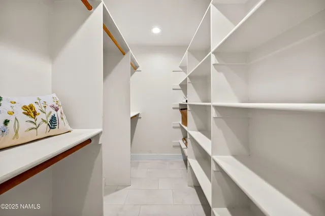 a hallway with a white cabinets and wooden floor