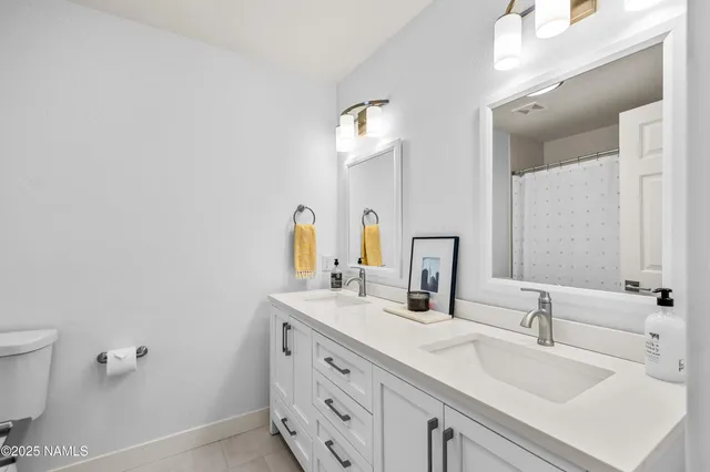 a bathroom with a double vanity sink and a mirror