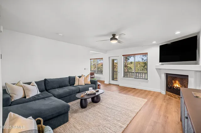 a living room with furniture a fireplace and a flat screen tv