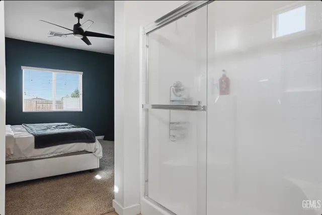 a bedroom with a bed and a chandelier fan