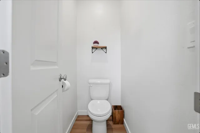 a white toilet sitting in a bathroom next to a wooden wall
