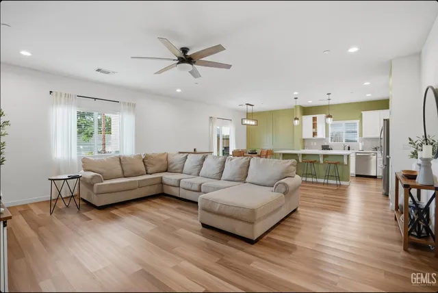 a living room with furniture and a view of kitchen