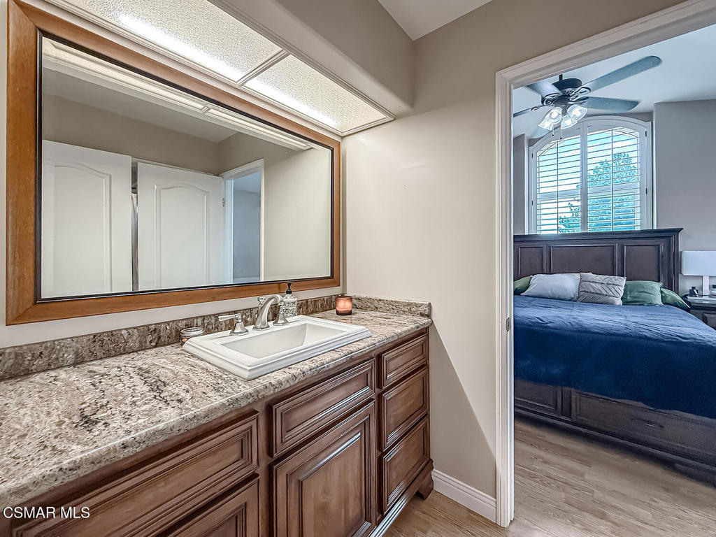 7204 University Drive Moorpark, CA 93021 - Photo 39 of 57 a bathroom with a granite countertop sink and a mirror