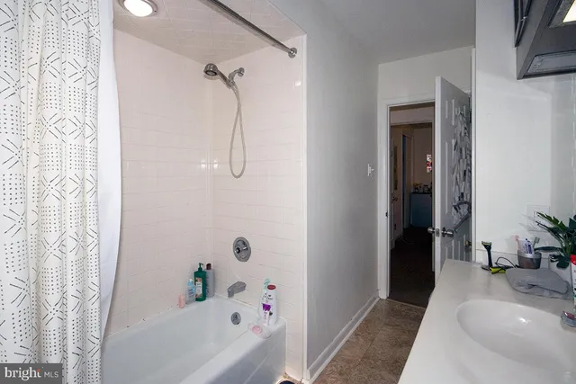 a bathroom with a tub a sink and a shower