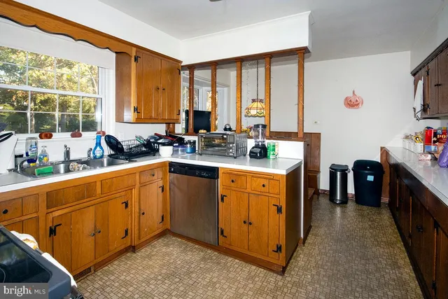 a kitchen with stainless steel appliances sink cabinets and window