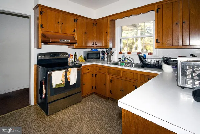 a kitchen that has a sink cabinets appliances and a window