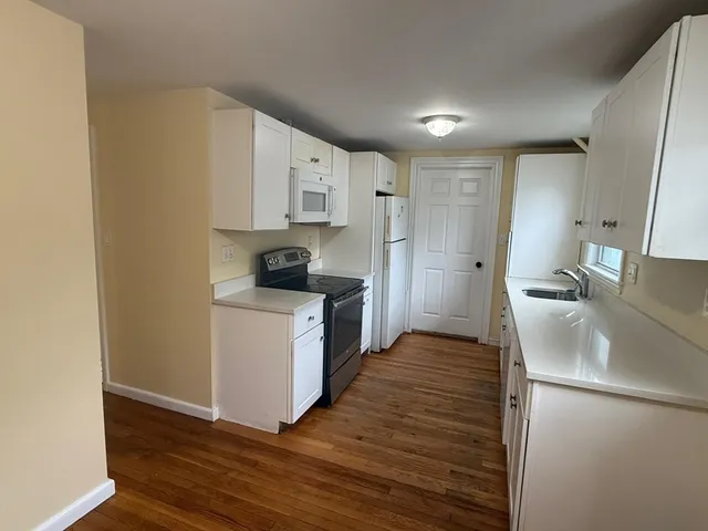 a kitchen with a refrigerator a stove top oven a sink and dishwasher