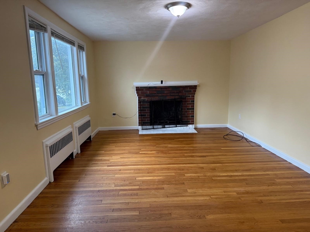 39 Alpena Avenue Dedham, MA 02026 - Photo 2 of 11 a view of an empty room with wooden floor and a window