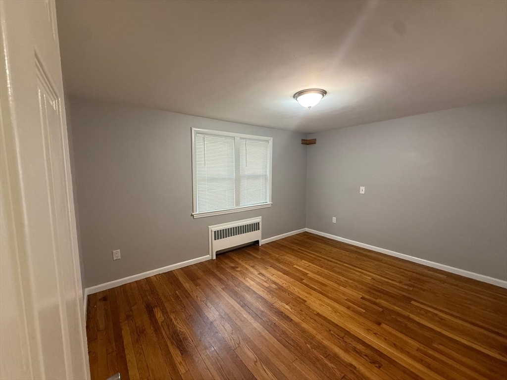 39 Alpena Avenue Dedham, MA 02026 - Photo 4 of 11 an empty room with wooden floor and windows
