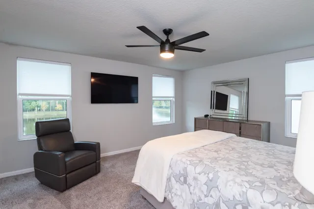 a bedroom with a bed window and a flat screen tv