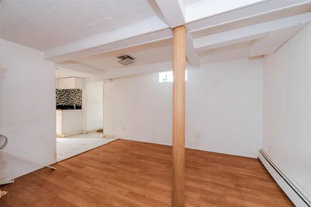 a view of a big room with wooden floor and windows