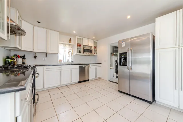a kitchen with stainless steel appliances a refrigerator sink and microwave