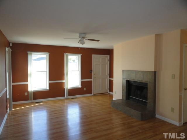 4204 Ferriday Court Raleigh, NC 27616 - Photo 3 of 9 a view of empty room with wooden floor and fireplace