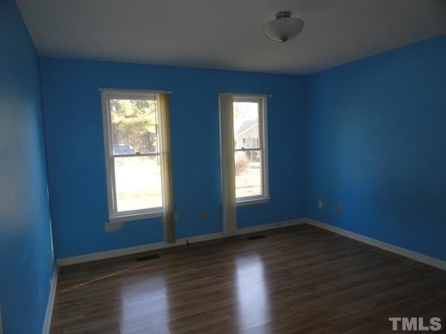 4204 Ferriday Court Raleigh, NC 27616 - Photo 6 of 9 an empty room with wooden floor and windows