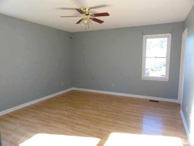 4204 Ferriday Court Raleigh, NC 27616 - Photo 7 of 9 an empty room with wooden floor fan and windows