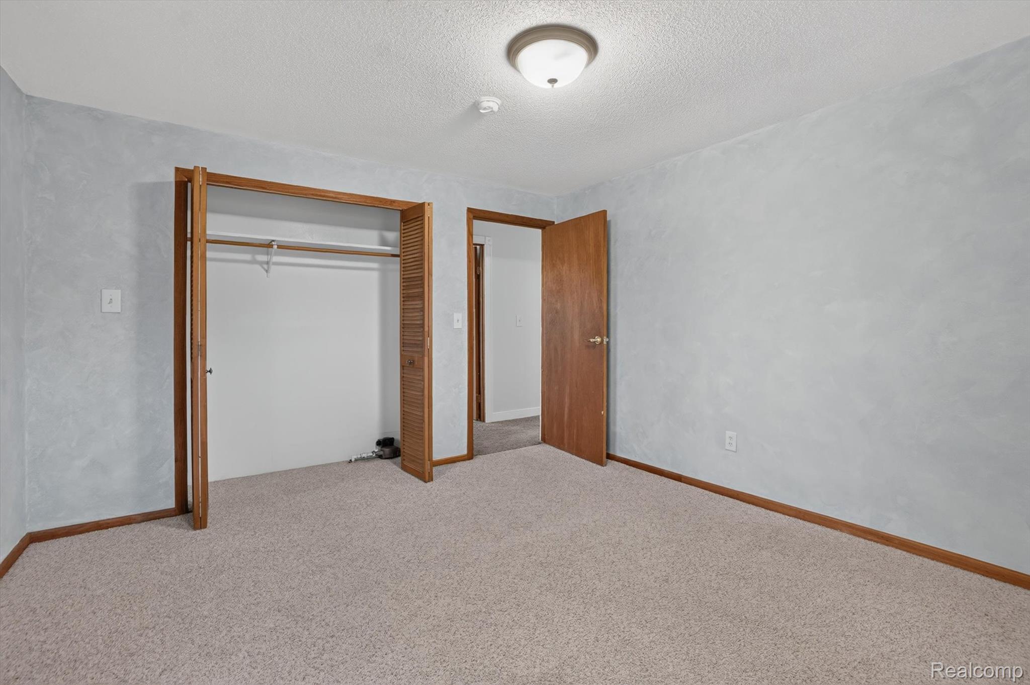 10977 Maple Road Birch Run, MI 48415 - Photo 27 of 49 Room featuring carpeting, a built-in closet with louvered bi-fold doors, and a flush-mount ceiling light fixture