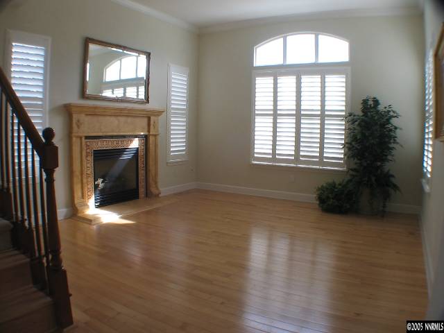 2950 Flint Ridge Court Reno, NV 89511 - Photo 3 of 7 an empty room with wooden floor a fireplace and windows