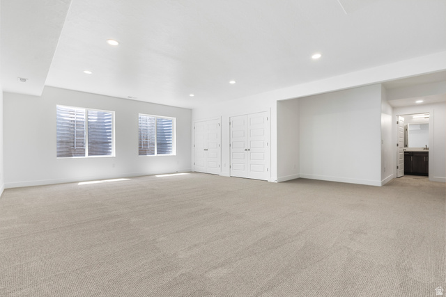 43 South Crimson Way, Unit 311 Mapleton, UT 84664 - Photo 18 of 28 Spacious lower-level room featuring light-toned carpeting, two egress windows, recessed ceiling lighting, and crisp white walls