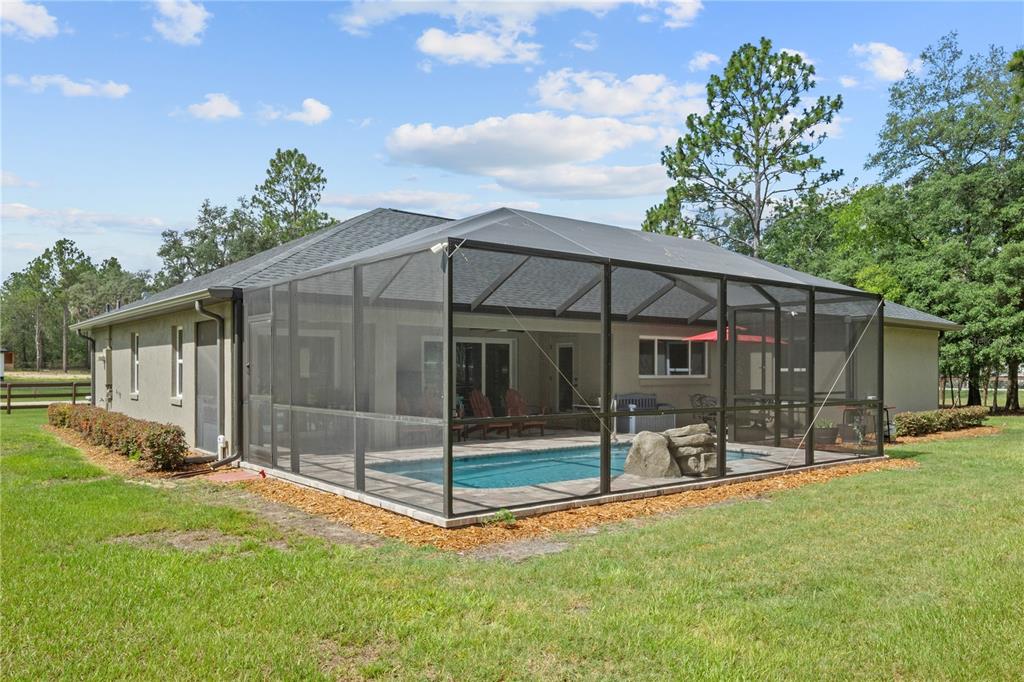 12929 Southwest 89th Street Dunnellon, FL 34432 - Photo 54 of 76 a backyard of a house with lawn chairs and wooden fence
