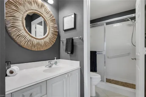 a bathroom with a sink a toilet and a mirror