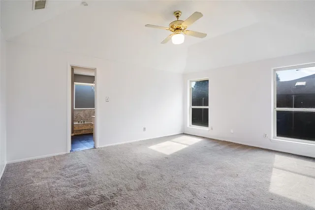 an empty room with closet and a ceiling fan