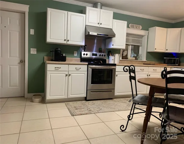 a kitchen with stainless steel appliances granite countertop a stove a sink and a white cabinets