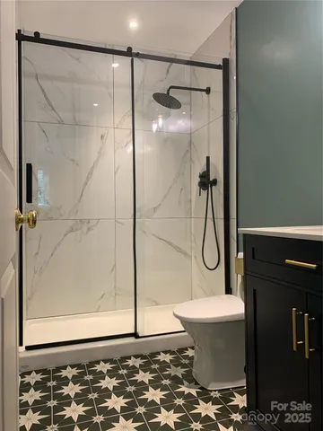 a bathroom with a granite countertop shower toilet and sink
