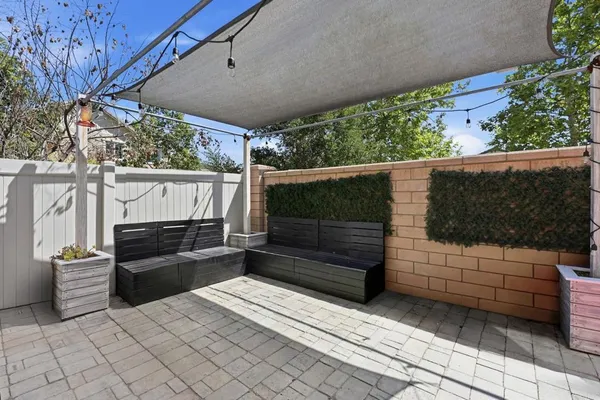 a view of a patio with table and chairs with wooden floor and fence
