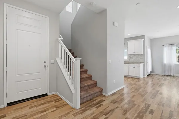 a view of a hallway with wooden floor and entryway