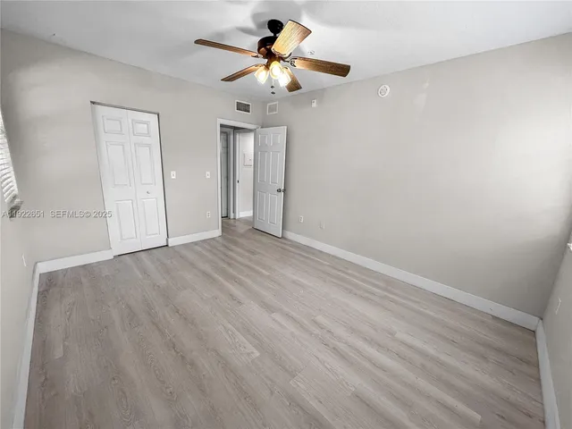 a view of room with hardwood floor and ceiling fan
