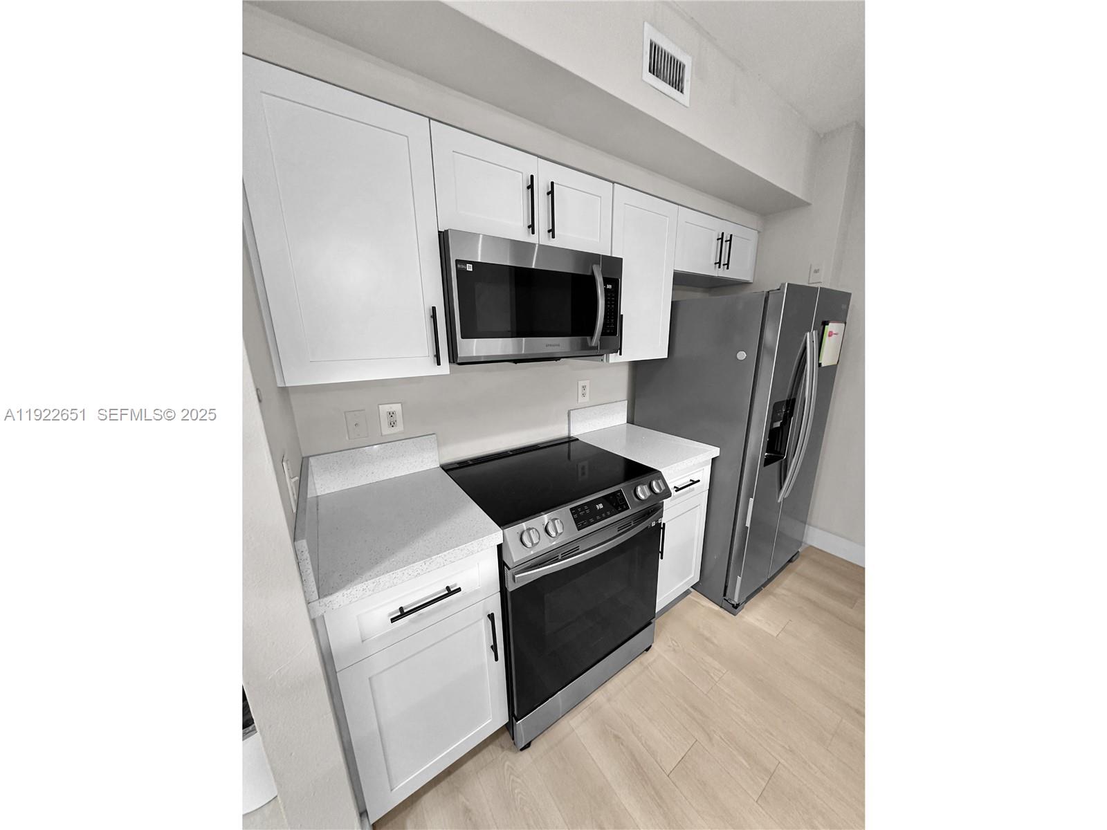 2120 West Preserve Way, Unit 301 Miramar, FL 33025 - Photo 8 of 28 a kitchen with a stove and a microwave