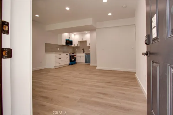 a view of a kitchen with cabinets and wooden floor