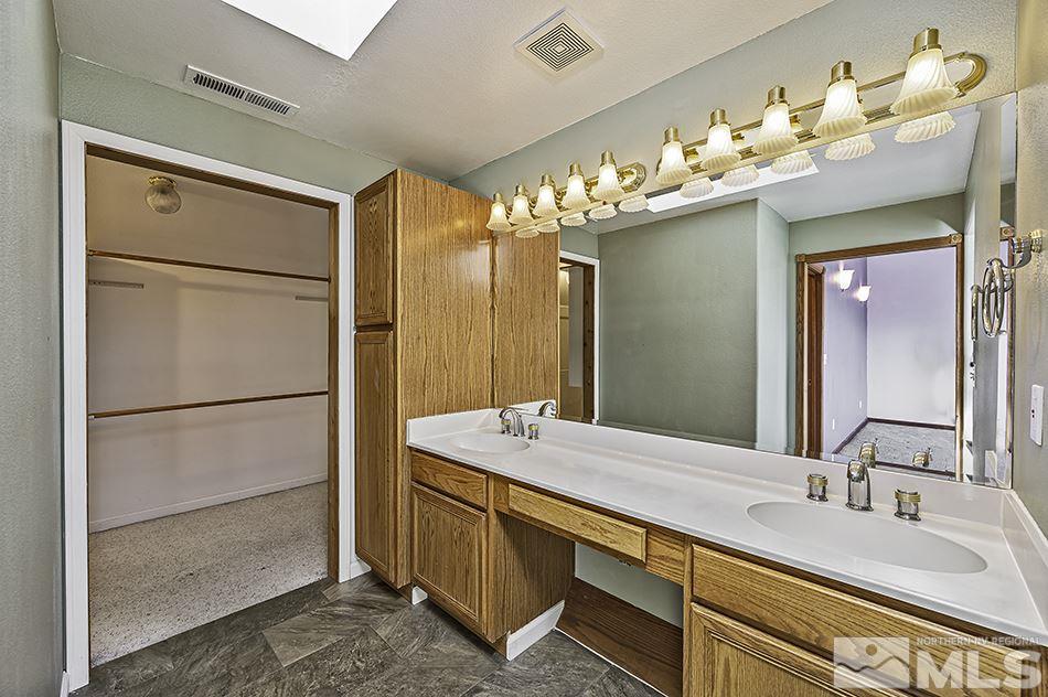 14300 Sitting Bull Circle Reno, NV 89521 - Photo 25 of 32 a bathroom with a double vanity sink and mirror