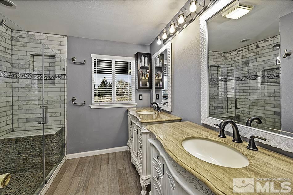 14300 Sitting Bull Circle Reno, NV 89521 - Photo 32 of 32 a bathroom with a granite countertop sink a mirror and shower