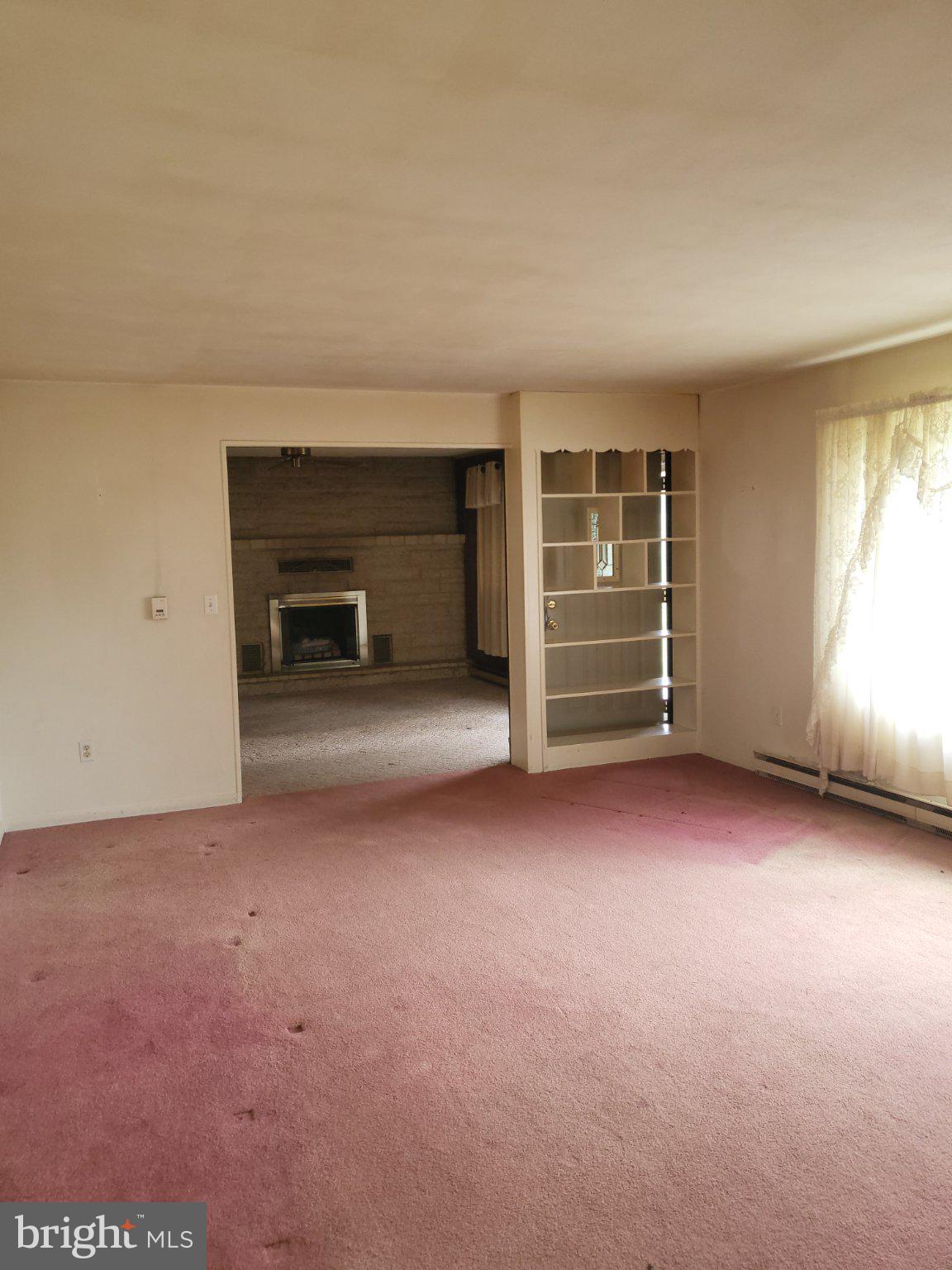 32 Sheetz Road Halifax, PA 17032 - Photo 6 of 20 an empty room with a fireplace cabinet and window
