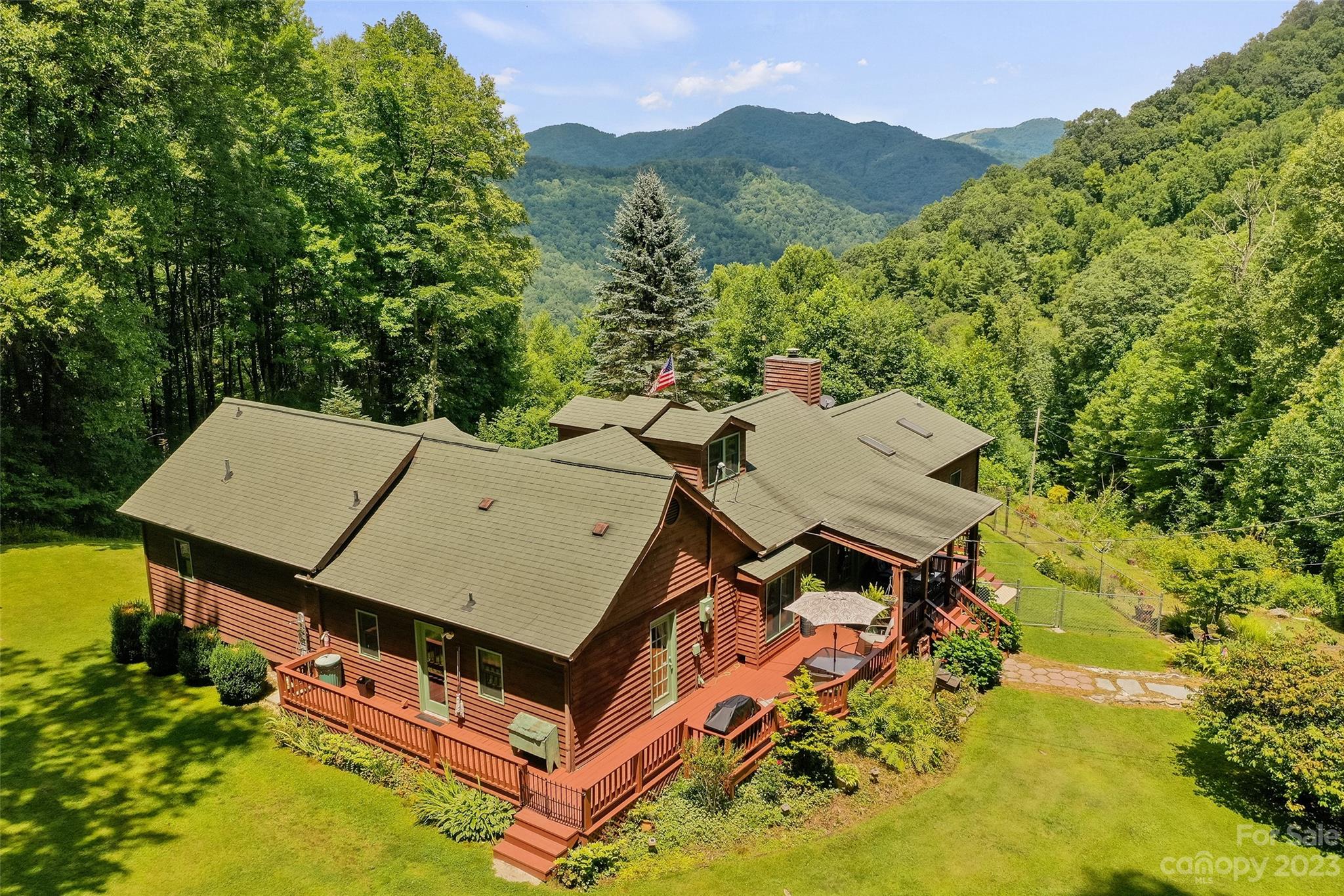 an aerial view of a house with a mountain