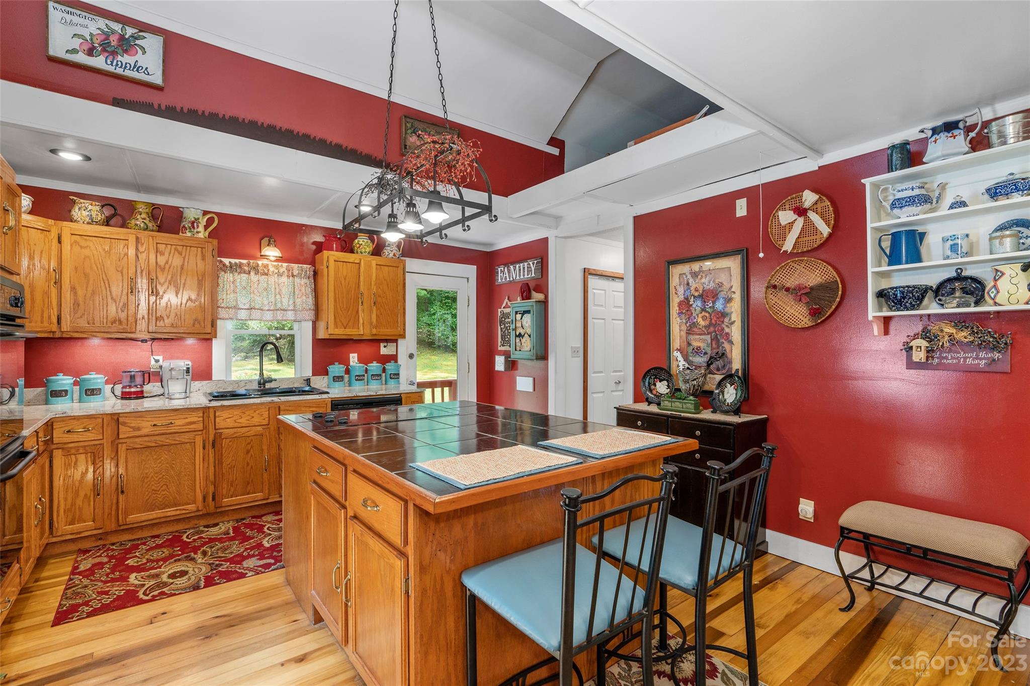 290 Last Mohican Trail Clyde, NC 28721 - Photo 17 of 46 a kitchen with stainless steel appliances kitchen island granite countertop a table chairs in it and wooden floors