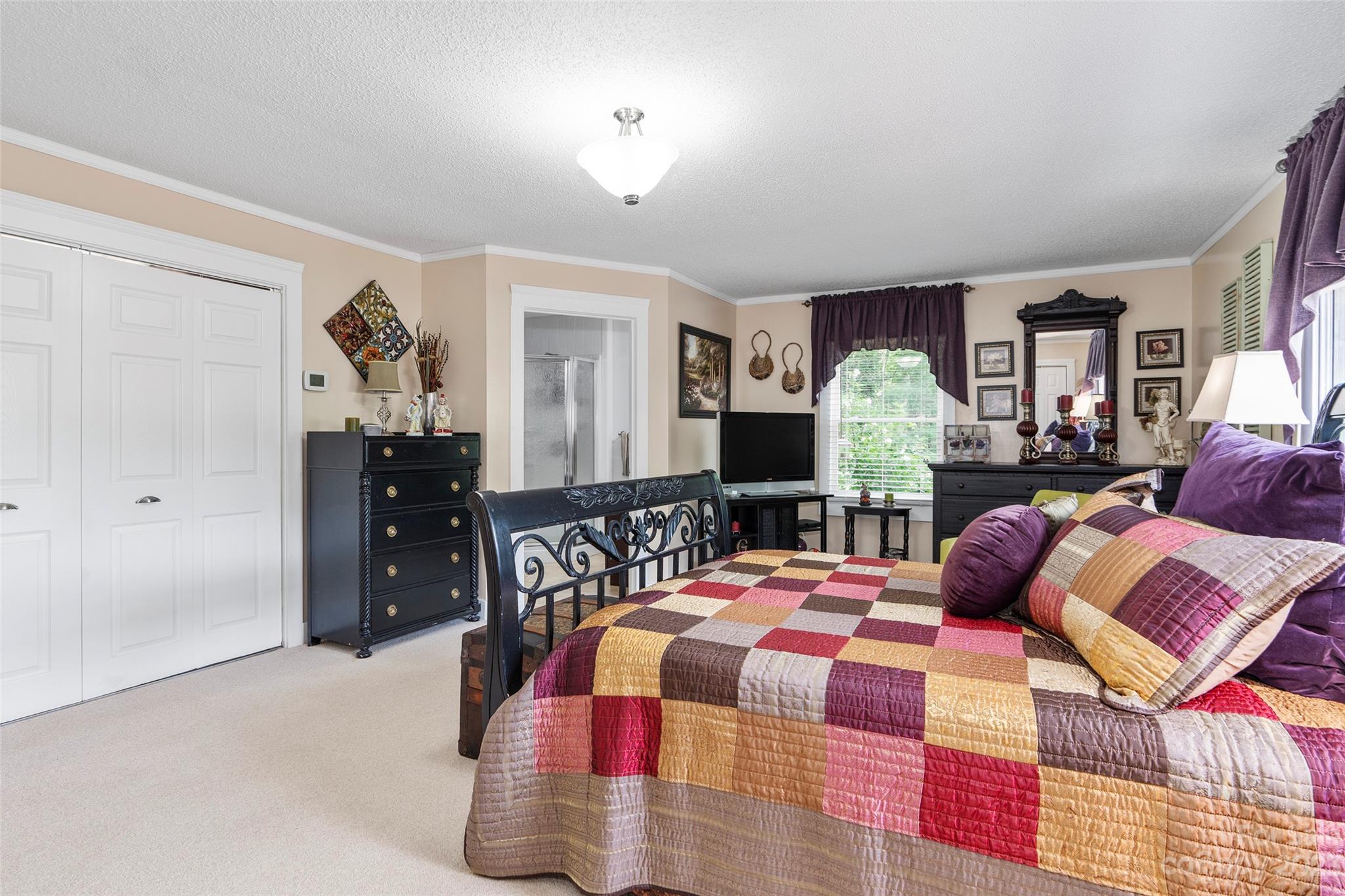 290 Last Mohican Trail Clyde, NC 28721 - Photo 22 of 46 a bedroom with a bed and lamp