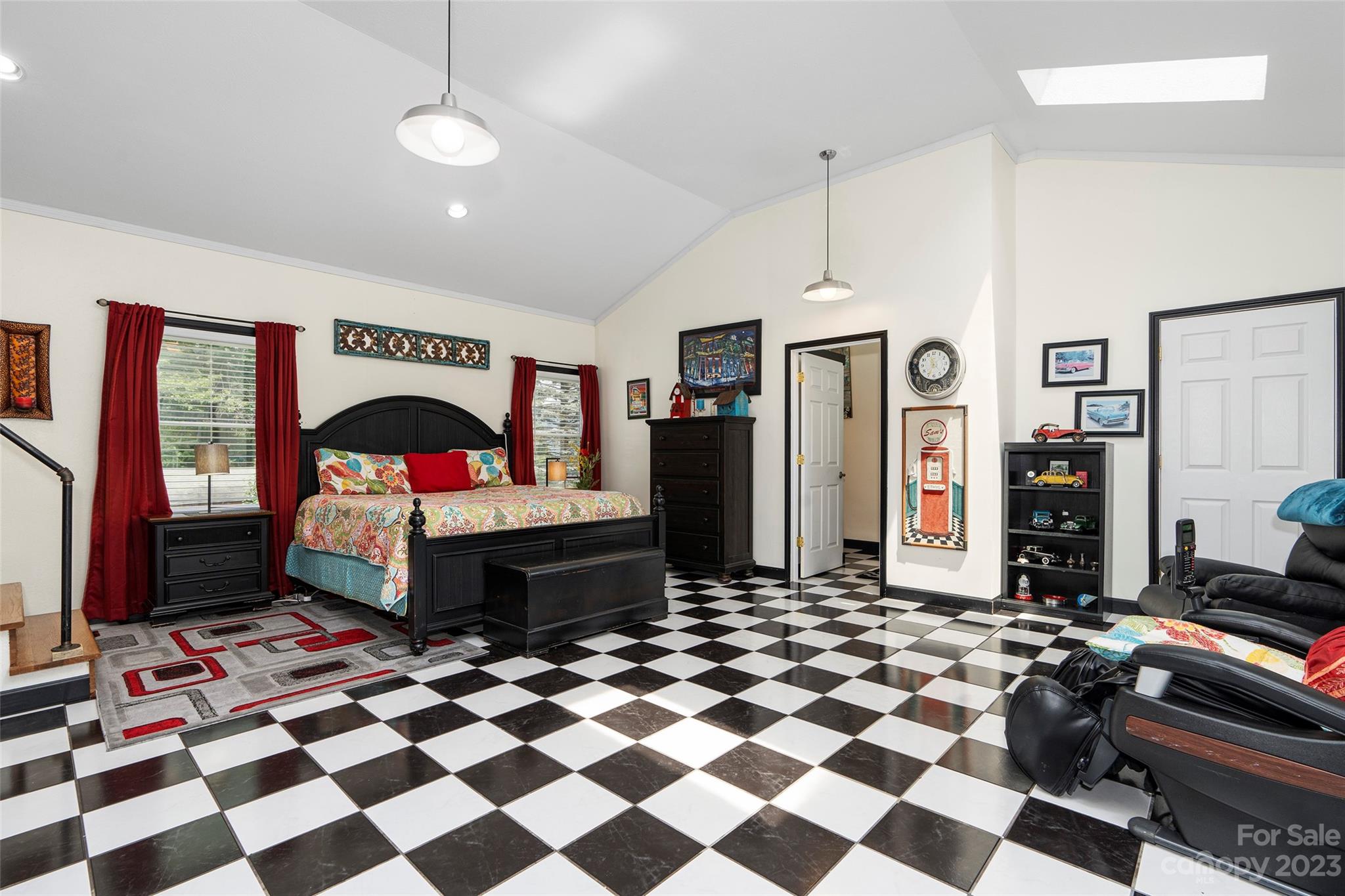 290 Last Mohican Trail Clyde, NC 28721 - Photo 31 of 46 a room with a black white checkered floor with a gaming machine and dining chairs