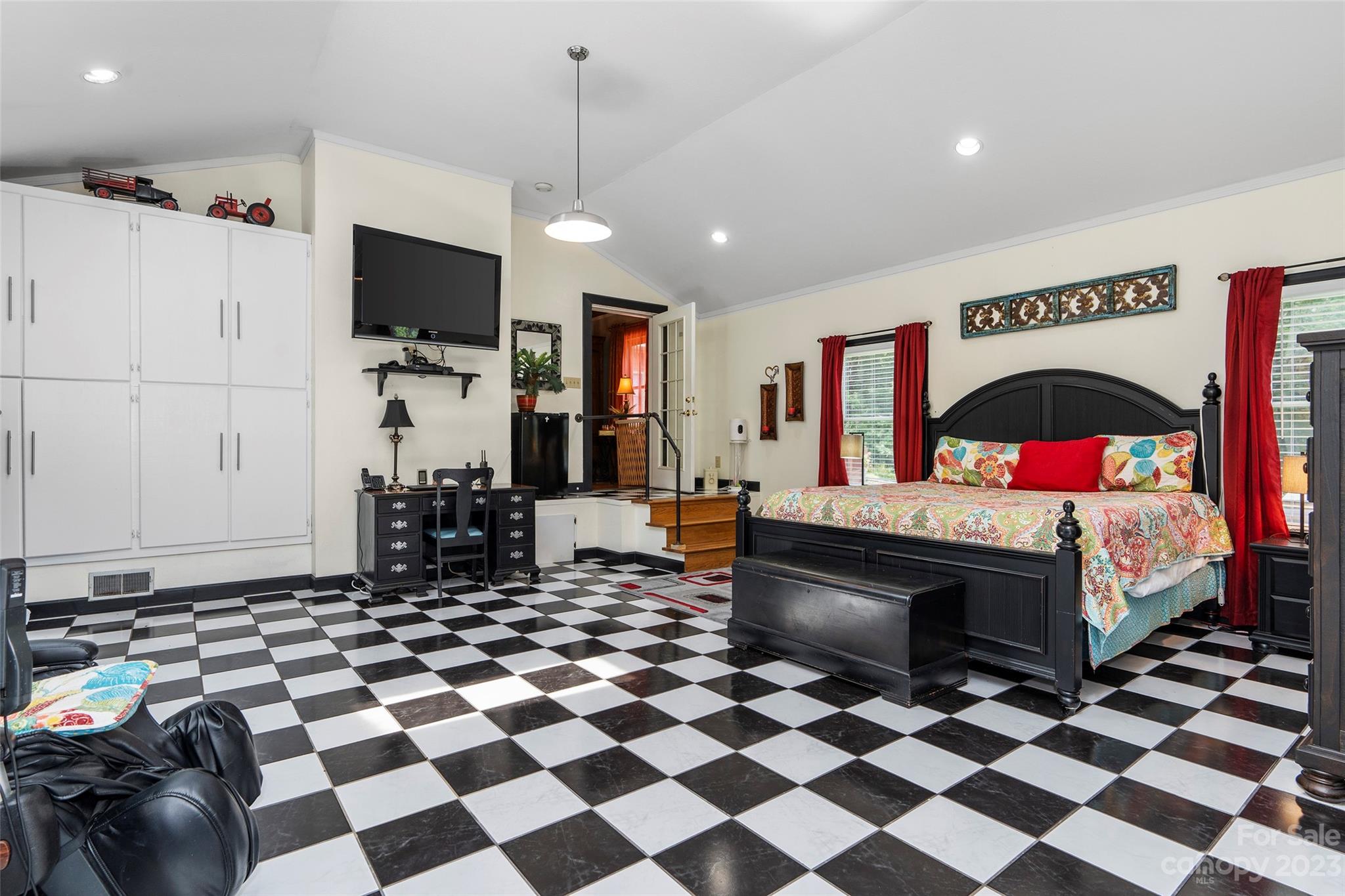 290 Last Mohican Trail Clyde, NC 28721 - Photo 33 of 46 a living room with a black white checkered floor with a gaming machine and dining chairs