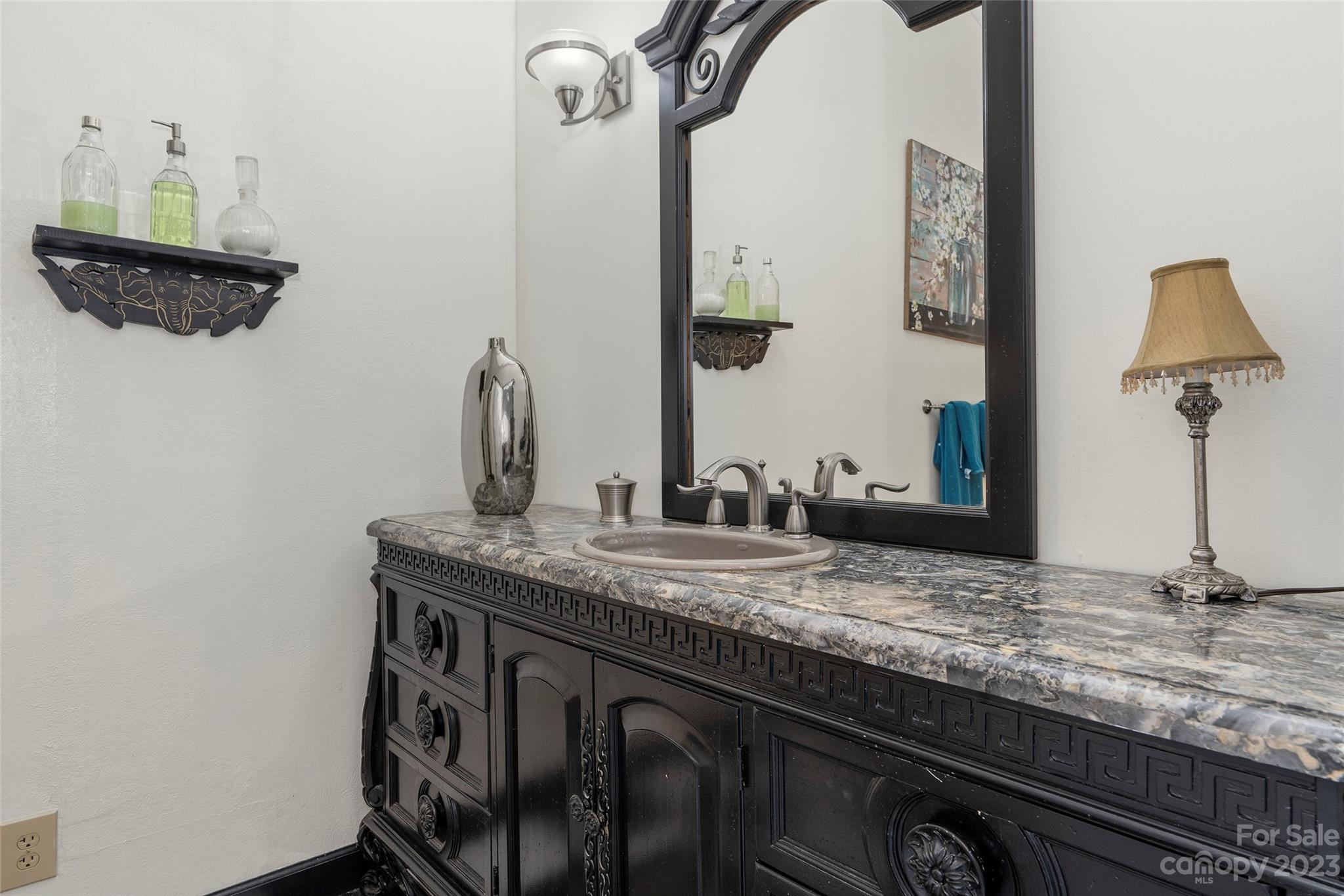 290 Last Mohican Trail Clyde, NC 28721 - Photo 34 of 46 a bathroom with a granite countertop sink and a mirror