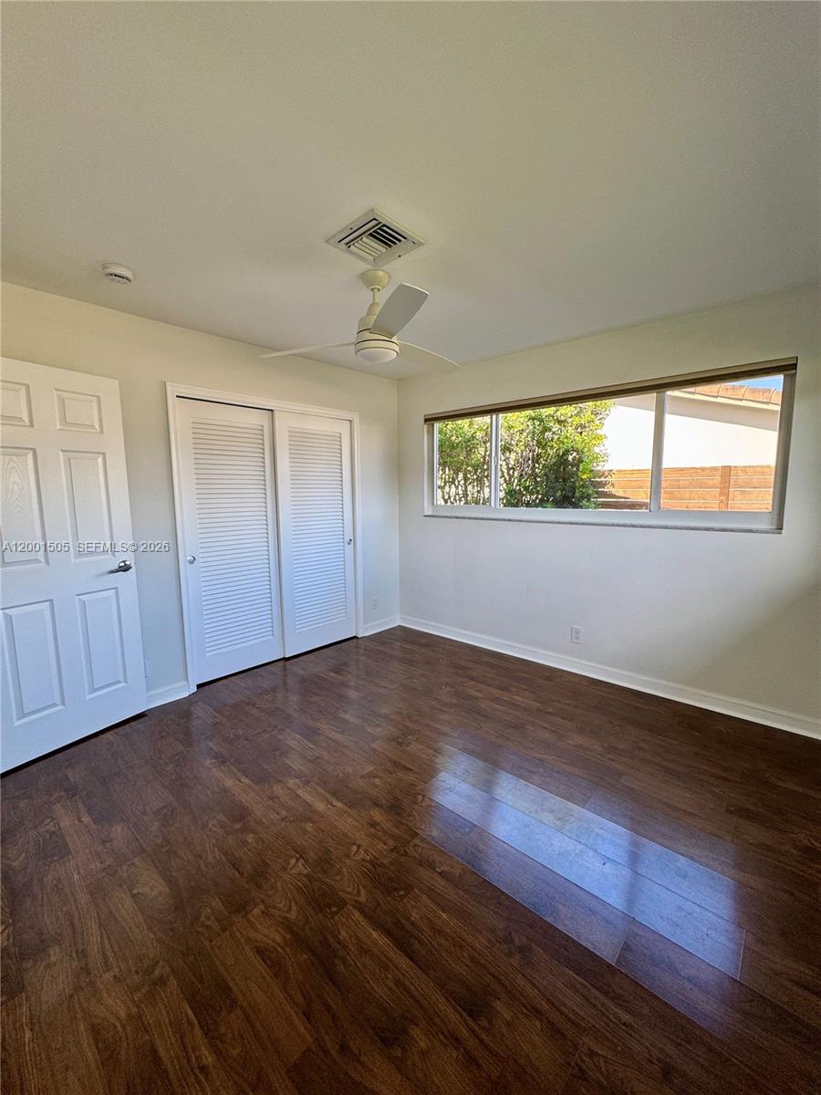 1093 Southwest 14th Street Boca Raton, FL 33486 - Photo 16 of 28 an empty room with wooden floor and windows
