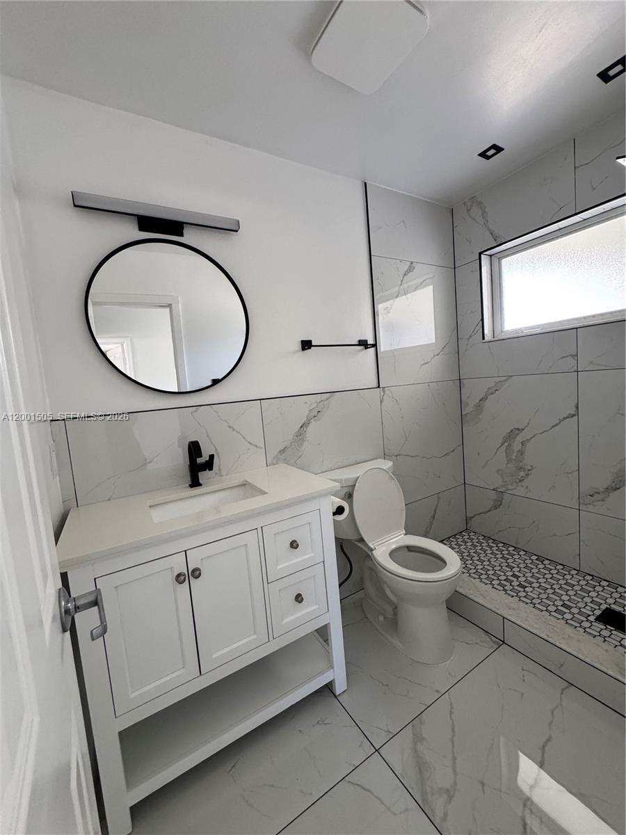1093 Southwest 14th Street Boca Raton, FL 33486 - Photo 17 of 28 a bathroom with a toilet sink and mirror
