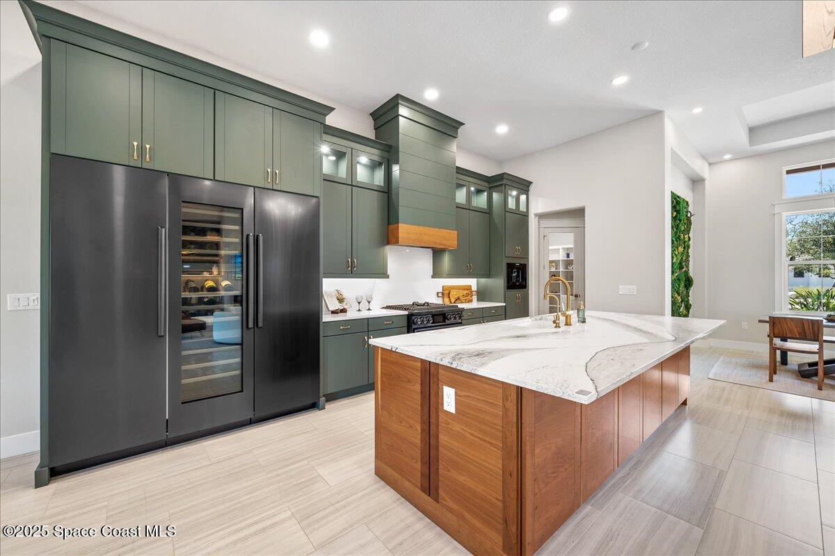 7953 Galikova Way Melbourne, FL 32940 - Photo 8 of 17 a large kitchen with stainless steel appliances kitchen island a large counter top and a refrigerator