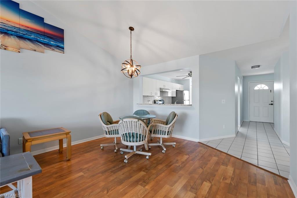 121 Gabriel Circle, Unit 1108 Naples, FL 34104 - Photo 11 of 41 a view of a dining room with furniture and wooden floor