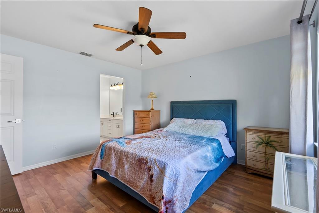 121 Gabriel Circle, Unit 1108 Naples, FL 34104 - Photo 16 of 41 a bedroom with a bed and a chandelier